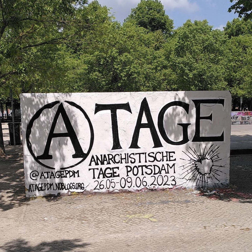 Transparent auf Platz zwischen Bäumen. Text: A-Tage, Anarchistische Tage Potsdam, @atagepdm, atagepdm.noblogs.org, 26.5.-9.6.2023